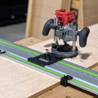 Black ToolCurve LR32 plate with spring-loaded pin on a green Festool rail, Milwaukee plunge router mounted, rail stops at each end