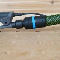 Black 36mm hose adapter with blue ring linking a green extractor hose to a 3M Xtract sander dust port