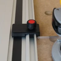 Black plastic limit stop with red knurled knob mounted on Milwaukee track saw guide rail
