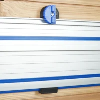 Blue and black 3D-printed wall mount with locking knob holding a Kreg ACS track saw rail on a wood wall