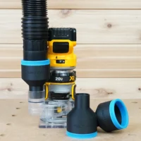 Black 2-1/2" hose adapter with blue trim on a Dewalt trim router, plus two loose adapters on the bench