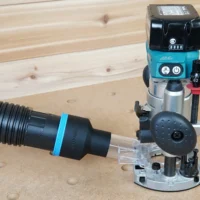 Black ToolCurve 2-1/2 inch hose adapter with blue band linking a vacuum hose to a Makita plunge router dust port