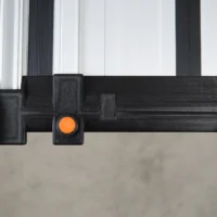 Black hose deflector mounted on guide rail with orange quick-release knob, front view