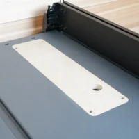 White MDF zero clearance insert mounted on SKIL 10" TS6307 table saw with central blade opening and offset screw holes