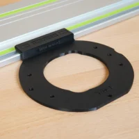 Black circular adapter with mounting holes, attached to a Festool guide rail with lime-green stripe