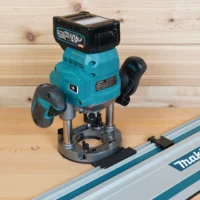 Black guide rail adapter mounted under a Makita 40V GPR01 plunge router, riding on a Makita guide rail