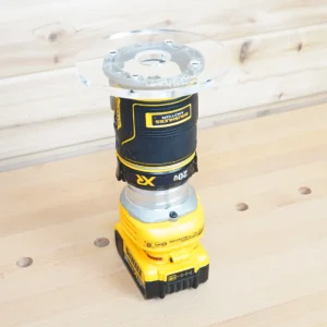 Clear 6-inch round acrylic router base plate mounted on an upside-down DeWalt cordless trim router