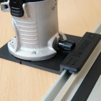 Porter Cable Trim Router mounted on black rail adapter connected to aluminum guide rail