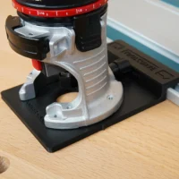 Rail adapter for Porter Cable trim router mounted on black base, silver and black metal housing with red depth scale ring visible above