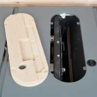 Zero clearance insert for Craftsman CMX 10" table saw, cream-colored MDF body shown next to black original insert to compare fit and construction