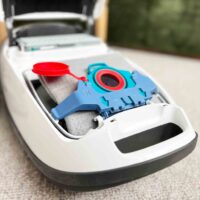 Blue and red reusable dust bag with microfleece filter insert sitting in white Miele vacuum canister