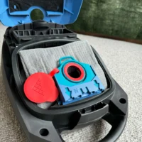 Macam reusable dust bag in blue and red inside open Miele vacuum canister, with red cap and gray filter visible
