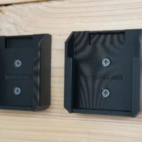 Two black plastic Makita 40V Max XGT battery mounts side by side, each with two screw holes and a slot at the top for battery insertion