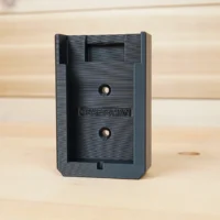 Black plastic Craftsman 20v battery mount with two mounting holes and internal clip slot, shown standing upright
