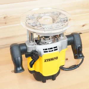 Clear 8-inch round acrylic router base plate mounted on an upside-down Dewalt 625 plunge router