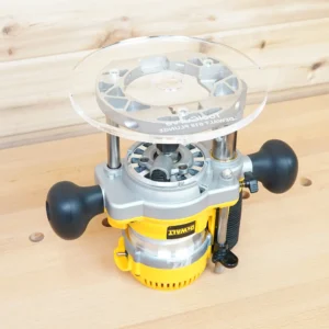 Clear 8-inch round acrylic router base plate with ToolCurve DeWalt 618 Plunge marking, mounted on a DeWalt plunge router