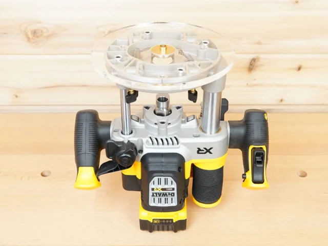8-inch round acrylic router base plate mounted on a DeWalt 2-1/4 HP cordless router, viewed from above on a wood surface